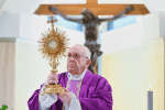 Pope Francis raises a monstrance during eucharistic adoration at the end of Mass on March 26 in the chapel of his Vatican residence, the Domus Sanctae Marthae. Photo: CNS/Vatican Media