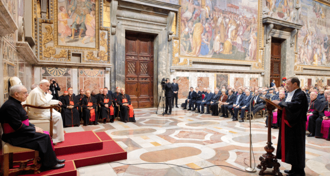 Pope Francis (left) listens as Gian Piero Milano (standing, right)the Vatican’s chief prosecutor, speaks during an audience on February 15. Photo: CNS/Vatican Media