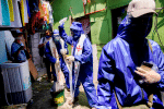Father Eduardo "Ponpon" Vasquez Jr. uses holy water to bless shanty homes in a poor section of Manila, Philippines, on april 20 during the Covid-19 pandemic. Photo: CNS/Reuters