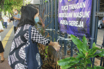 A parishioner of Our Lady of the Assumption Cathedral washes her hands before entering to attend Sunday Mass on July 12. Photo: UCAN/Katharina R. Lestari
