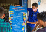 A Catholic Relief Services staff member in Cambodia explains the latest Covid-19 information to a small group of village leaders in July. Photo: CNS/CRS