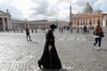 A priest wearing a surgical facemask walks along a street just outside St. Peter’s Square at the Vatican on October 12. Photo: CNS/Reuters