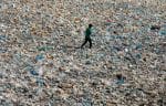 A boy walks over a drainage channel littered with garbage in Karachi, Pakistan, on Earth Day 2020. Photo: CNS/Reuters