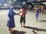 Sister Derama gives bread to a homeless man in Cebu.