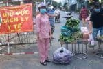 Residents collect vegetables given by Caritas workers on a street in Ho Chi Minh City on July 7. Photo UCAN/courtesy of caritasvietnam.org=-0o9i