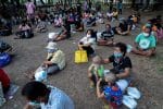 People maintain social distancing while waiting for free meals at a park in Bangkok in April 2020. Photo: CNS/Athit Perawongmetha, Reuters