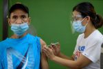 A man receives his first dose of a Covid-19 vaccine at a school in Manila. Photo: CNS/Lisa Marie David, Reuters