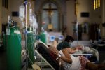 A Covid-19 patient rests in the chapel of Quezon City General Hospital, the Philippines. The chapel was turned into a Covid-19 ward amid rising delta variant infections in the Philippines. Photo: CNS /Eloisa Lopez, Reuters