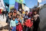 Syrian refugee, Abd al-Razzak Dasher, stands with his children at an informal tent settlement in the Bekaa Valley in Lebanon. Photo: CNS/Mohamed Azakir, Reuters