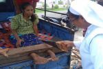 A nun saws through a wooden foot stock to free a girl shackled by her family because she suffers from mental illness. Photo: UCAN/supplied