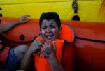 A migrant boy with fuel burns on his face sits in an inflatable boat operated by a German nongovernment organisation after being rescued in international waters in the Mediterranean Sea off the coast of Libya on July 30. Photo: CNS/Darrin Zammit Lupi, Reuters