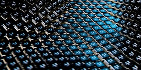 Dense grid of small blue and black tiles, each with a white AI-like logo, forming a diagonal pattern.