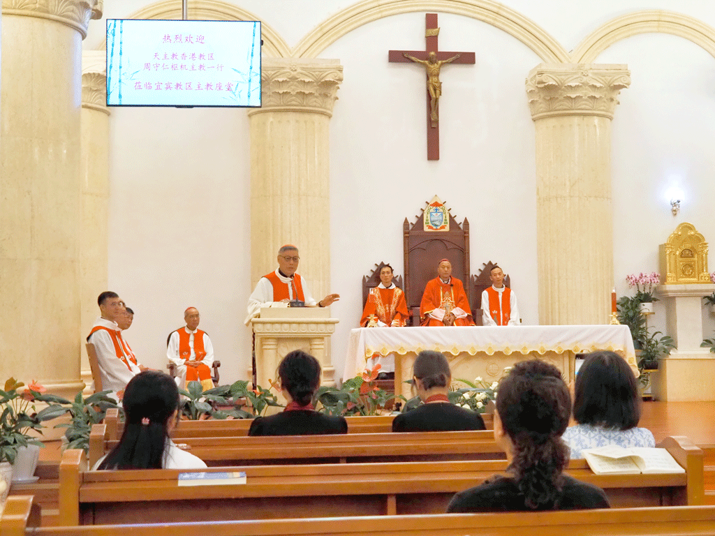 Clergy dressed in orange vestments lead a church service at an altar with a crucifix behind them.